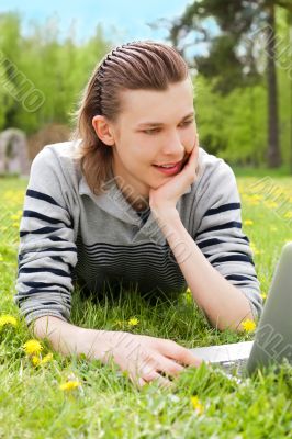 A smiling man with laptop outdoor