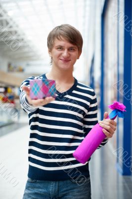 Portrait of young man inside shopping mall standing relaxed and 
