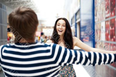 Young man meeting his girlfriend with opened arms at airport arr
