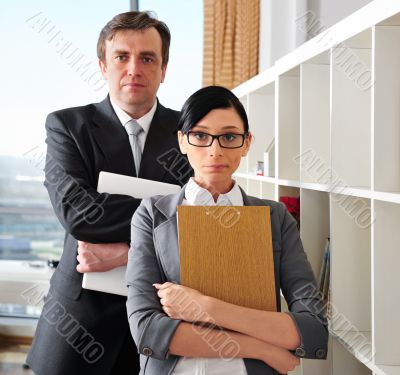 Closeup portrait of caucasian colleagues: young woman holding fo