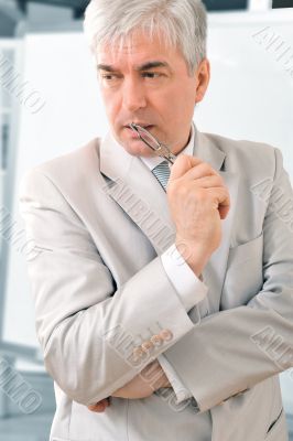 Closeup of a mature smiling business man standing in a light at 