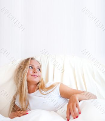 Young blond woman enjoying a sunny morning in bed