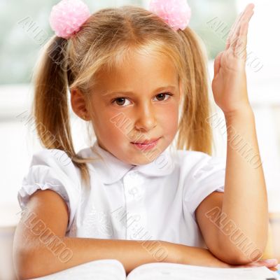 Portrait of a young girl in school at the desk.