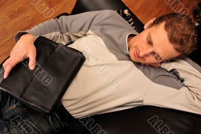 Happy young man sitting on sofa at home
