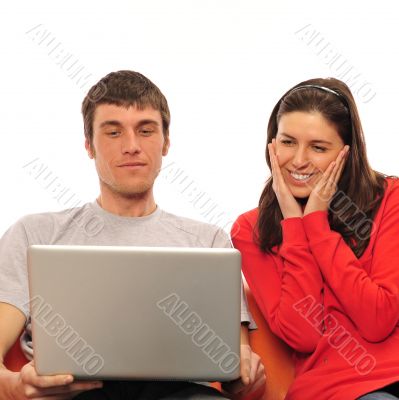 Young romantic couple sitting on their sofa and enjoying fast wi Young romantic couple sitting on their sofa and enjoying fast wi