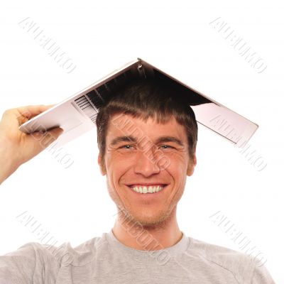 Portrait of young man holding his laptop on his head like roof o