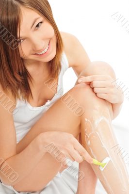 Cute woman shaving her legs
