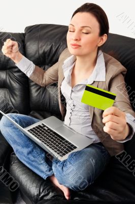 Portrait of a young woman lying on the couch and shopping from t