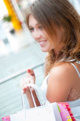 Happy shopping woman at the mall preparing gifts for her friends
