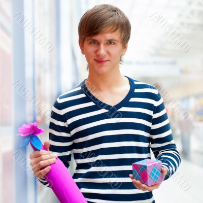 Portrait of young man inside shopping mall standing relaxed and 