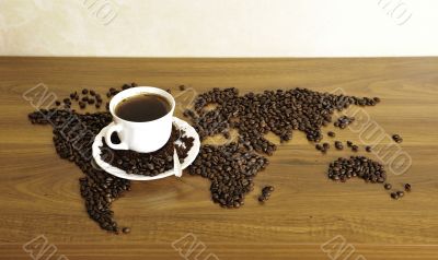 Dramatic photo of world map made of coffee beans. White cup with