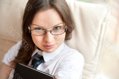 Portrait of a happy young brunette woman holding book