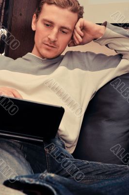 Happy young man  sitting on sofa at home