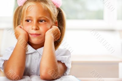 Image of smart child reading interesting book in classroom