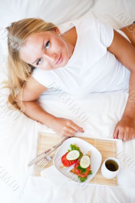 Woman having breakfast in bed. Healthy continental breakfast. Ca