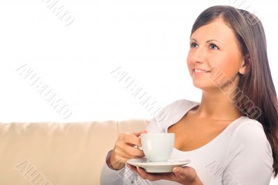 Young woman at home sipping tea from a cup