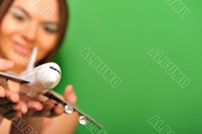 Pretty young woman playing with plastic airplane on green backgr