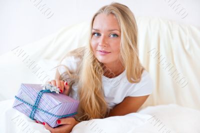 Bedroom surprise present - young happy woman in bedroom