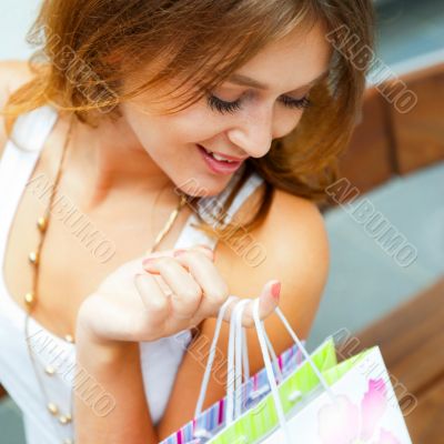 Happy shopping woman with bags and smiling. She is shopping insi