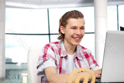 Portrait of handsome young man working with laptop on freelance 