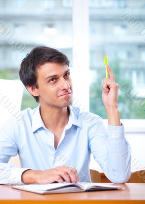 Businessman sitting indoors and writing plan in his diary Businessman sitting indoors and writing plan in his diary