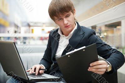 Portrait of handsome young man working with laptop at cafe at bu