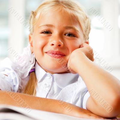 Portrait of a young girl in school at the desk.
