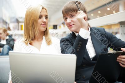 Two students working on their college project at hall using lapt