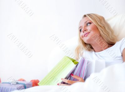 Young happy attractive girl unpack shopping bags in bedroom or h