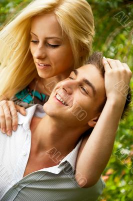 Portrait of love couple embracing outdoor in park looking happy Portrait of love couple embracing outdoor in park looking happy