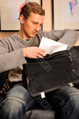 Happy young man sitting on sofa at home