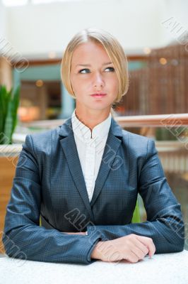 Portrait of pretty young businesswoman sitting relaxed and looki