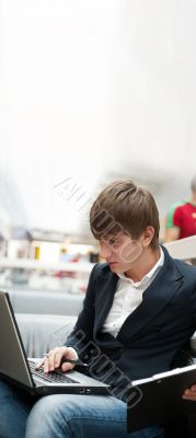Portrait of handsome young man working with laptop at cafe at bu