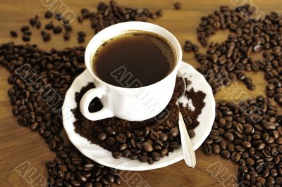 Dramatic photo of world map made of coffee beans. White cup with