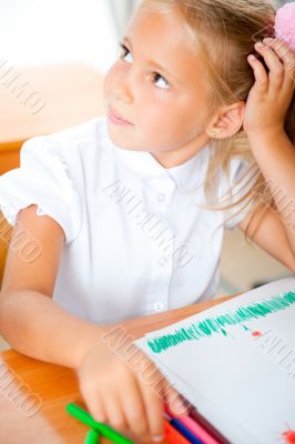 Little girl looking for a drawing concept wile painting picture 