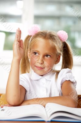 Portrait of a young girl in school at the desk.
