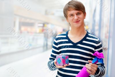 Portrait of young man inside shopping mall standing relaxed and 