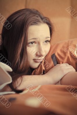 Closeup portrait of young pretty girl laying on her bed