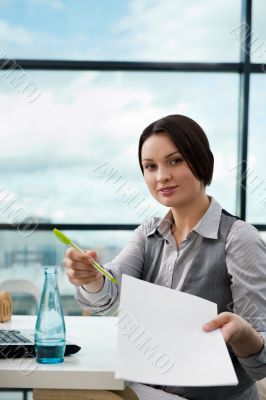 Portrait of a happy young agent giving pen and blank agreement t