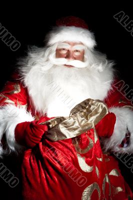 Santa sitting at the Christmas room and looking into the sack