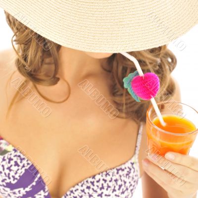 Woman drinking orange juice and wearing summer hat. Vacation con