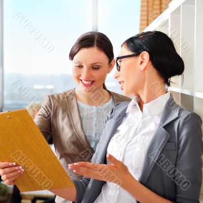 Two business women reading documents