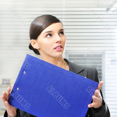 A portrait of a young business woman in an office with documents