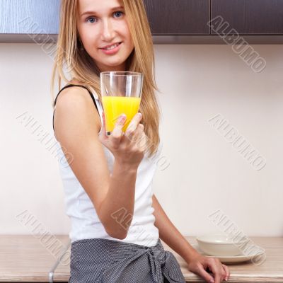 Portrait of beautiful relaxed young woman standing at the kitche
