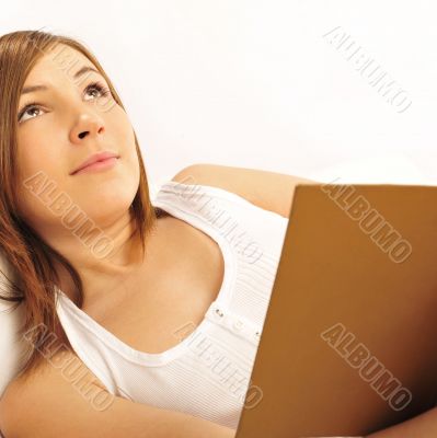 Closeup portrait of beautiful young brunette woman on the bed at