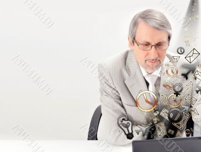 Closeup of a mature smiling business man sitting at his office a