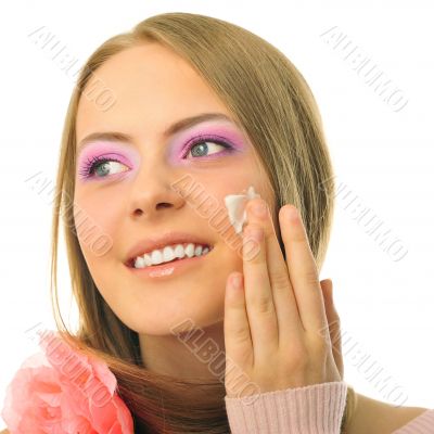 Beautiful woman applying moisturizer cosmetic cream on face - on