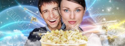 Portrait of young stylish modern couple watching movie against f