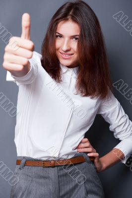 Portrait of a beautiful young business woman standing and thumbs