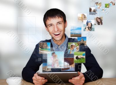 Portrait of young happy man sharing his photo and video files in
